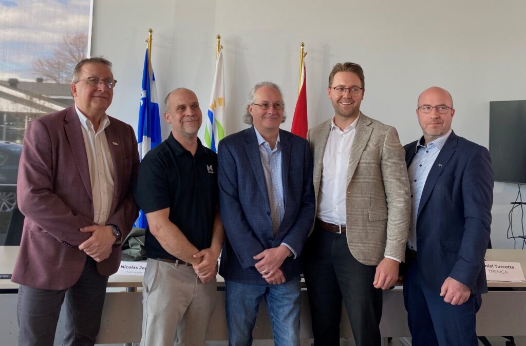 Cinq dirigeants d'entreprises réunis devant les drapeaux dans une salle de réunion