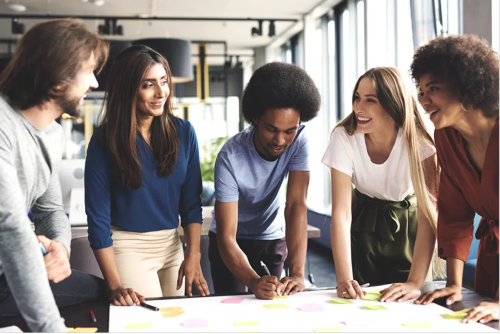 5 jeunes entrepreneurs diversifiés, brainstorming avec post-its colorés