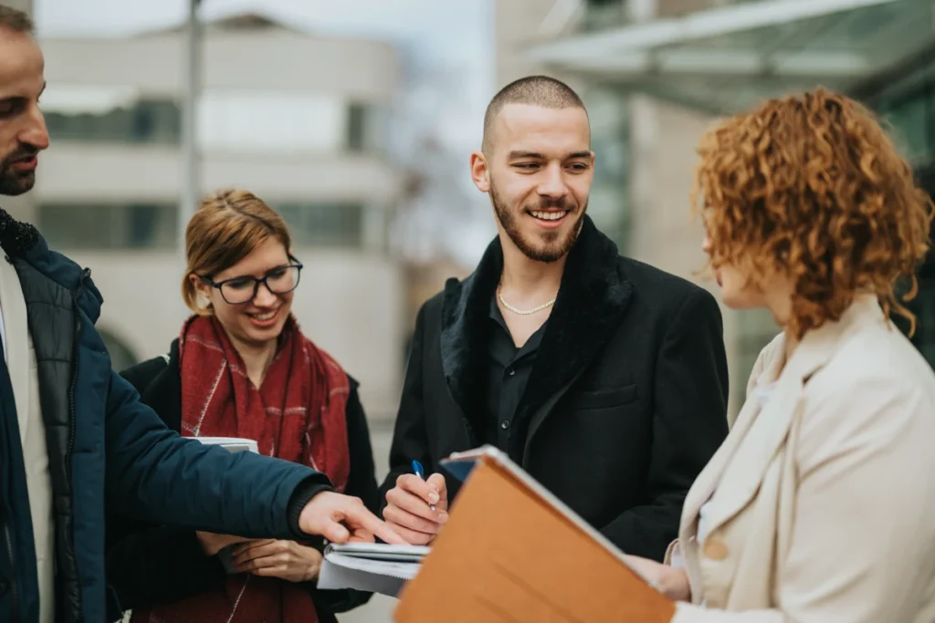 Jeunes entrepreneurs signent un document à l’extérieur