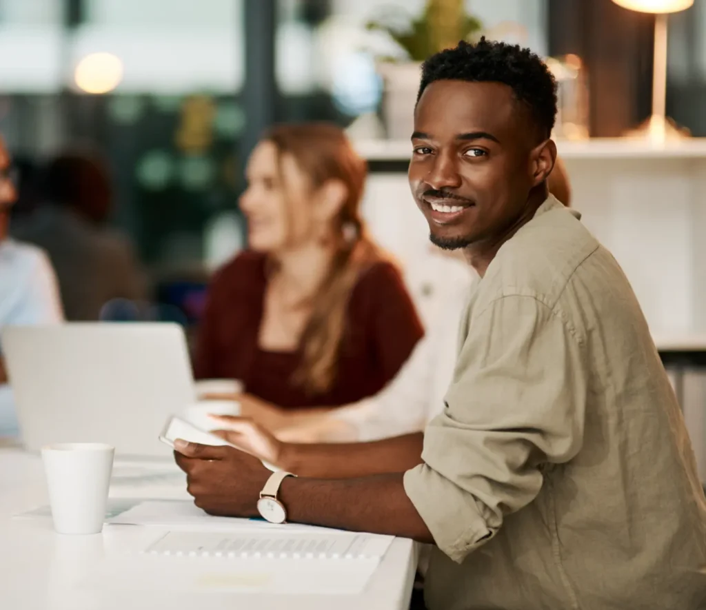 Homme souriant en réunion de bureau moderne