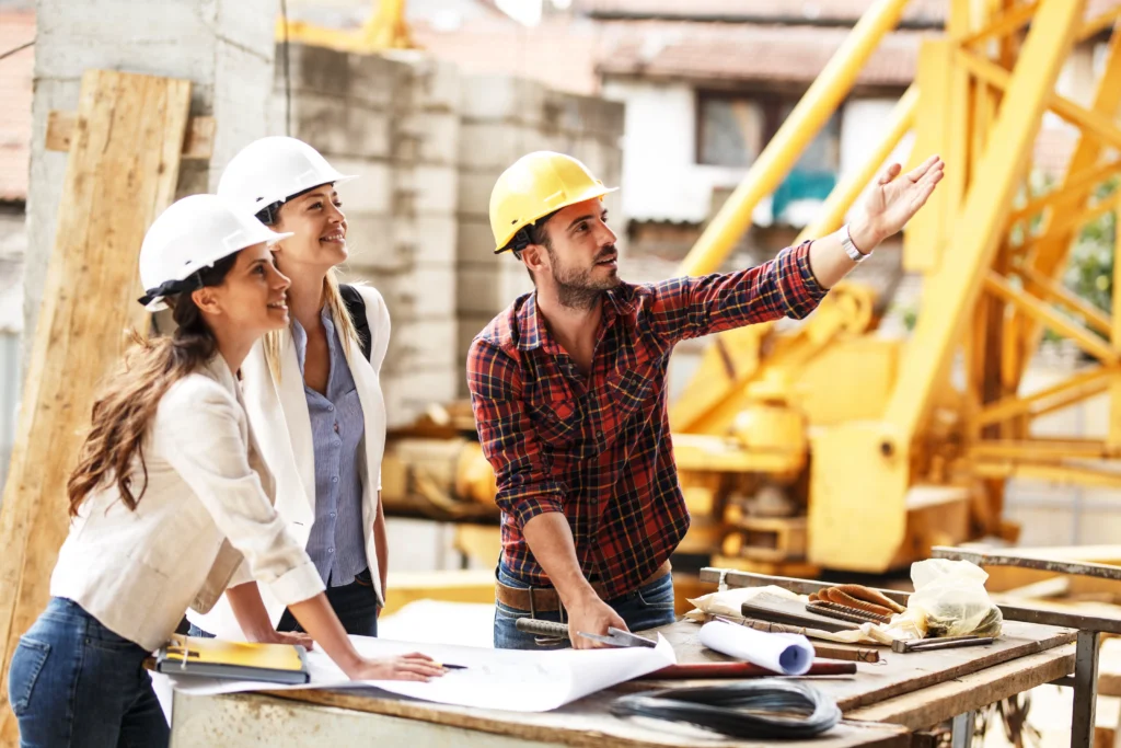 Professionnels du bâtiment examinant des plans sur chantier