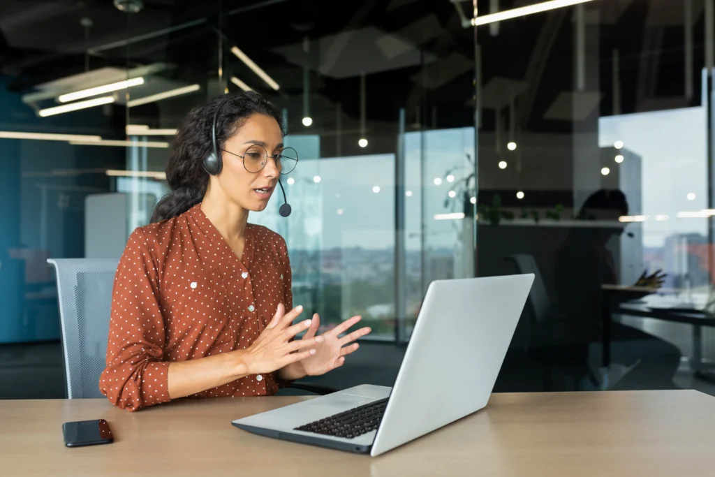 Femme en visioconférence avec casque au bureau