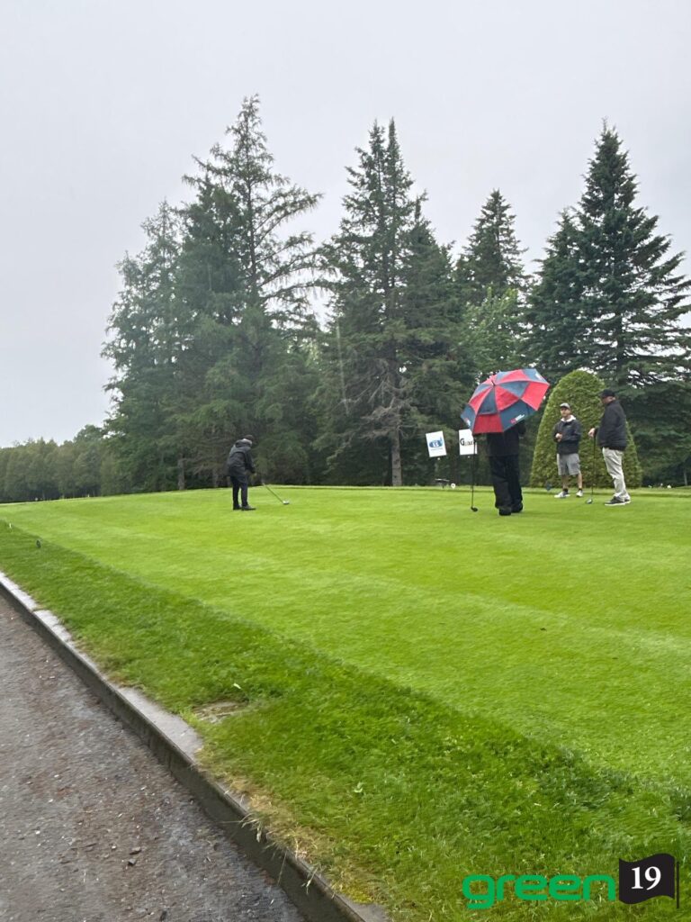 Joueurs de golf sous la pluie sur le green