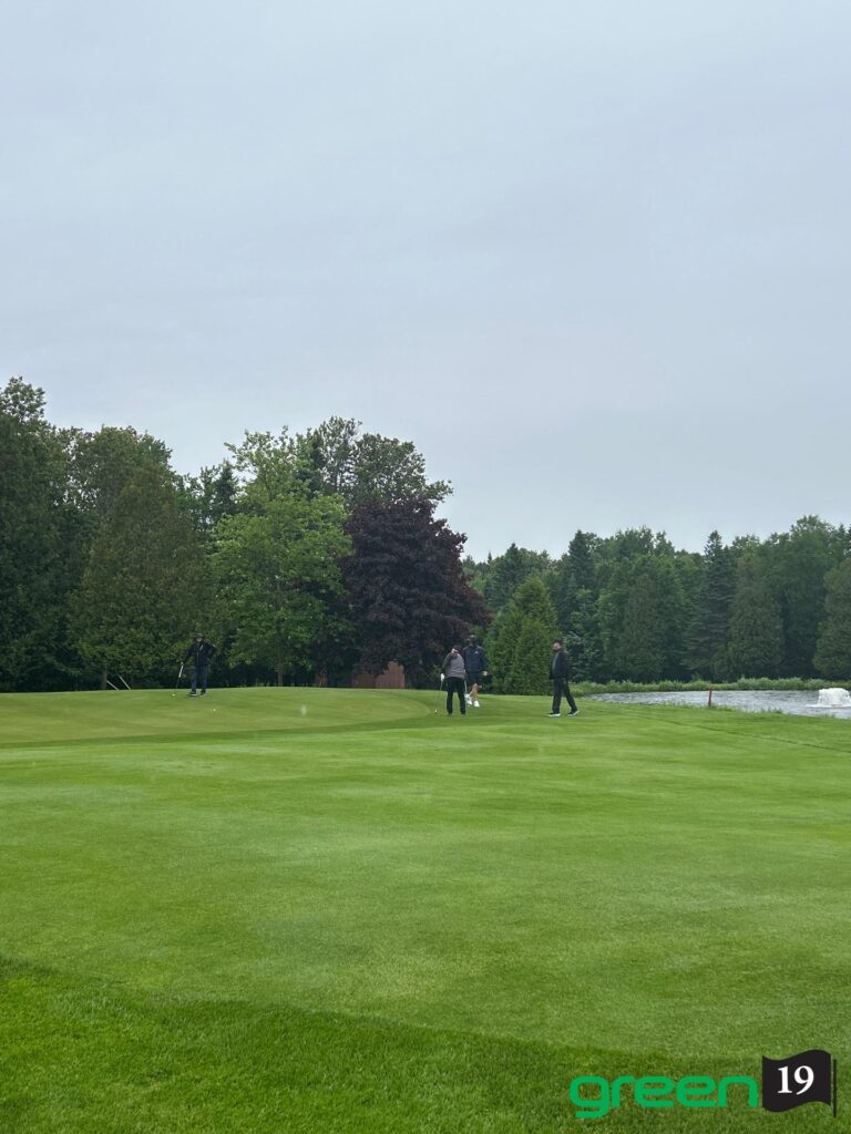 Golfeurs sur un green près d’un étang