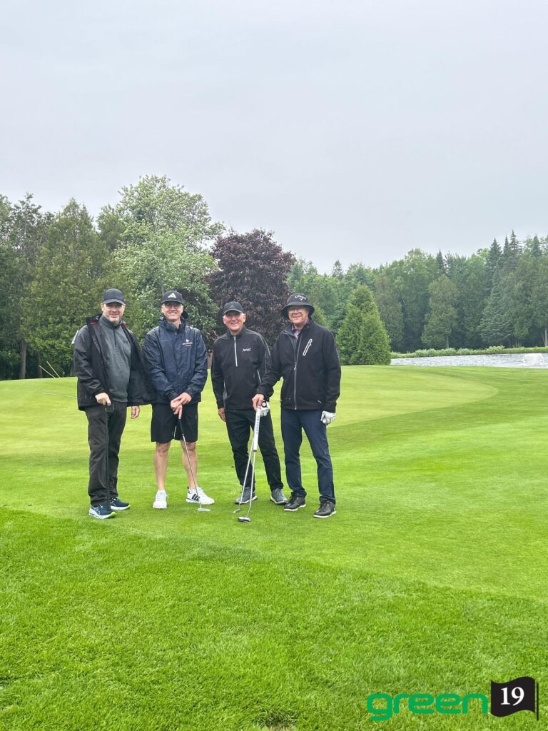 Quatre golfeurs posant sur un green