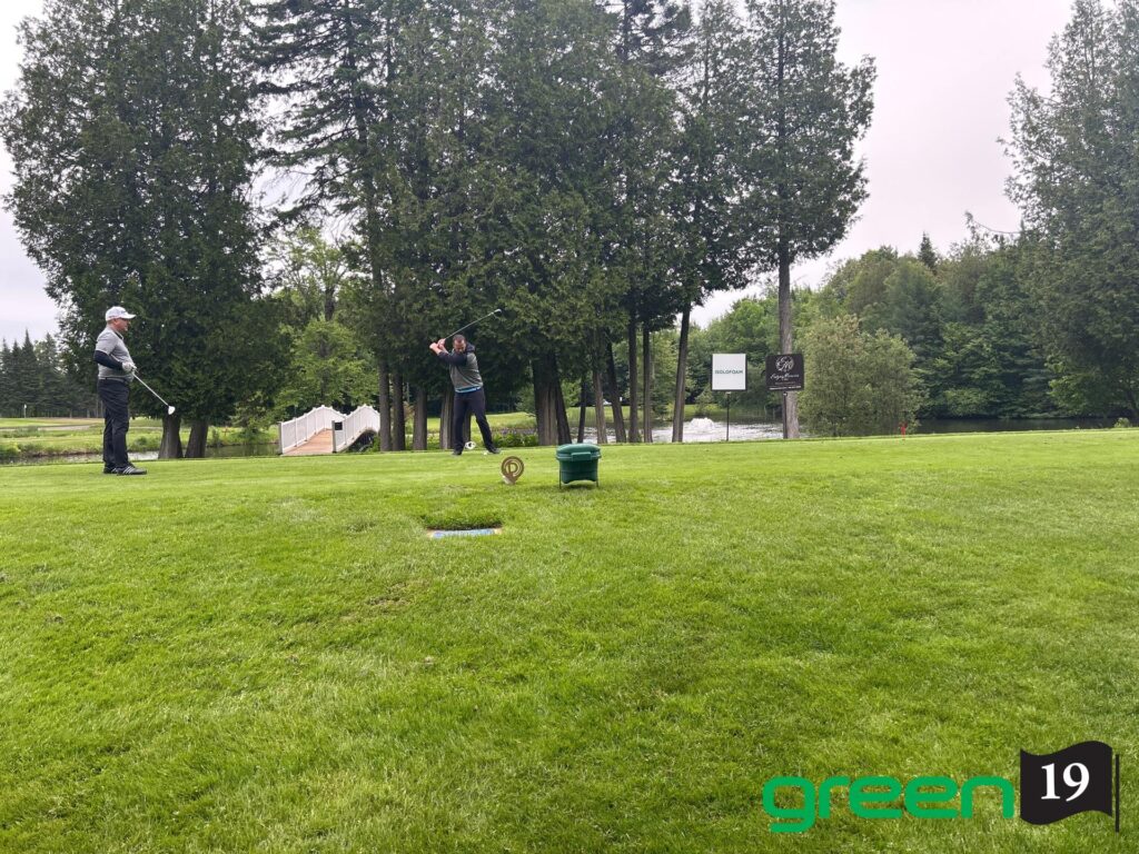 Deux golfeurs sur un green entouré d’arbres