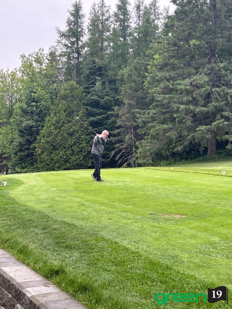 Homme frappant une balle sur un parcours de golf