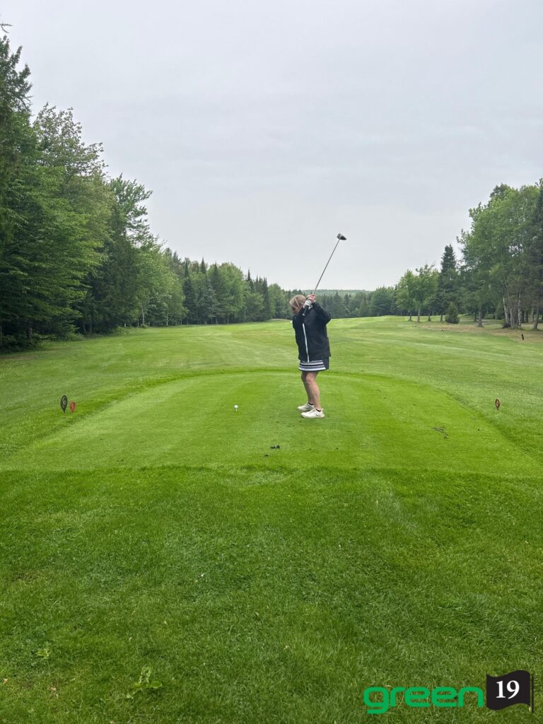 Golfeuse effectuant un drive sur fairway verdoyant