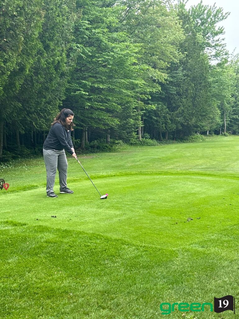 Femme effectuant un drive sur un parcours de golf