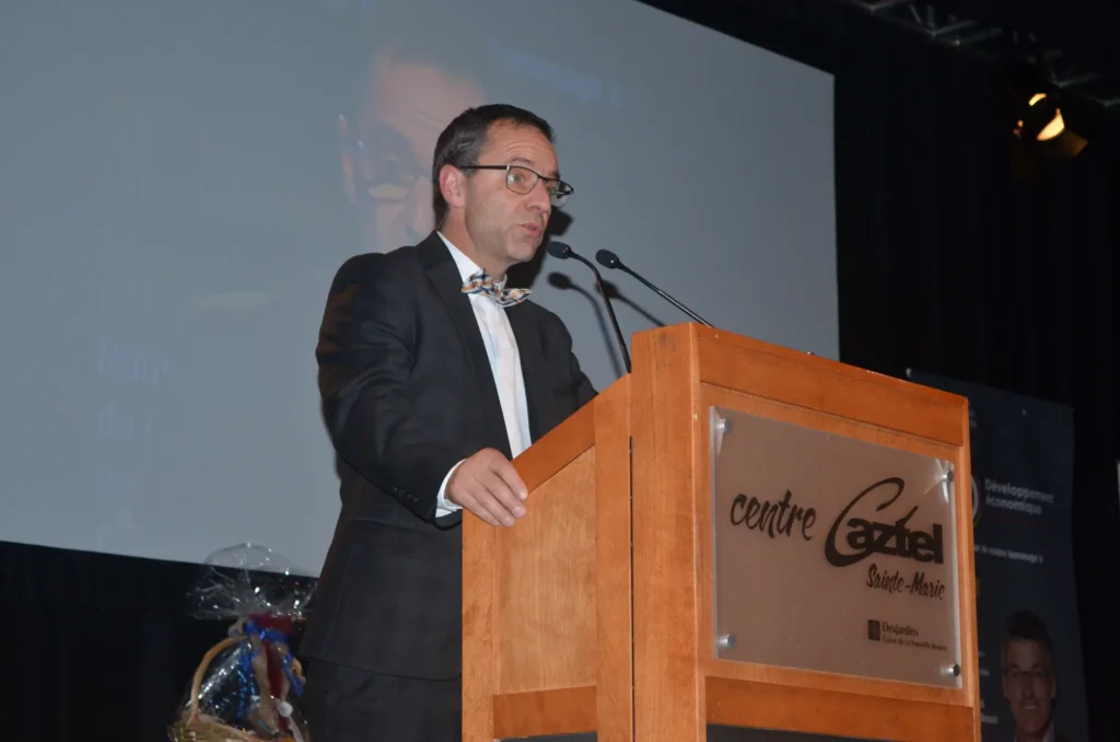 Homme en costume prononçant un discours au pupitre