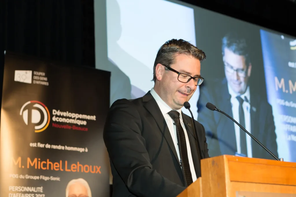 Homme en costume prononçant un discours au podium