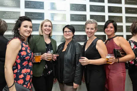 Cinq femmes souriantes lors d’un événement professionnel