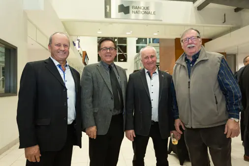 Quatre hommes posant dans un hall bancaire