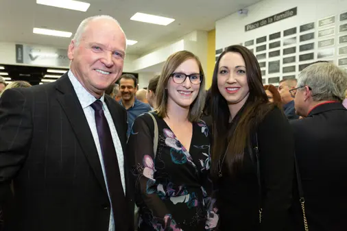 Trois personnes souriantes lors d’un événement intérieur