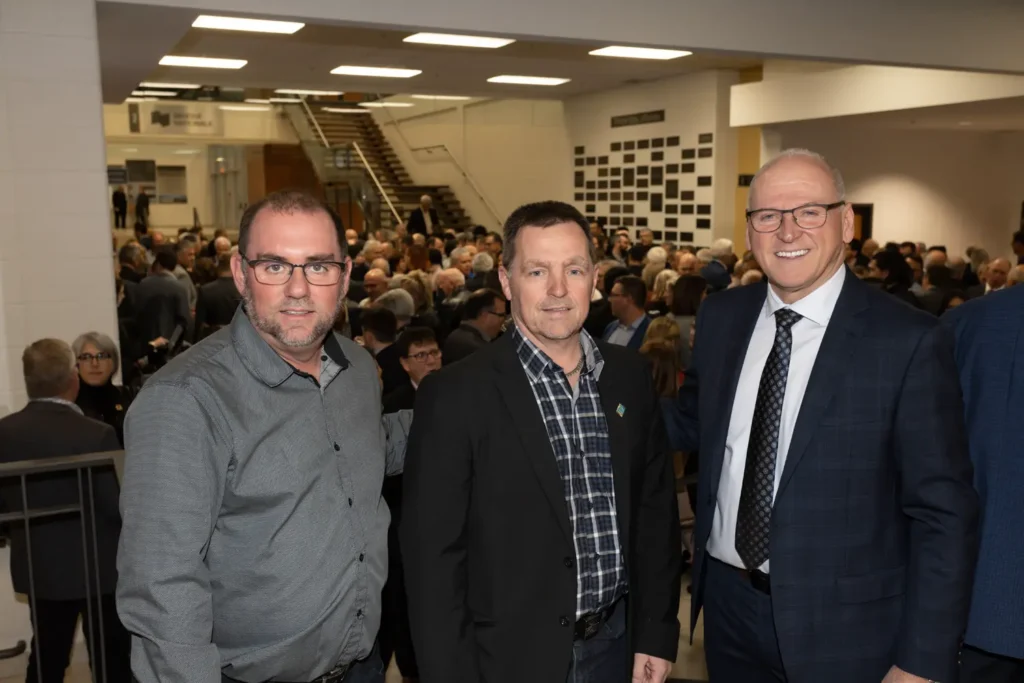 Trois hommes posent lors d’un événement public