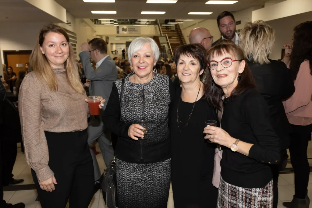Quatre femmes souriantes lors d’un événement intérieur
