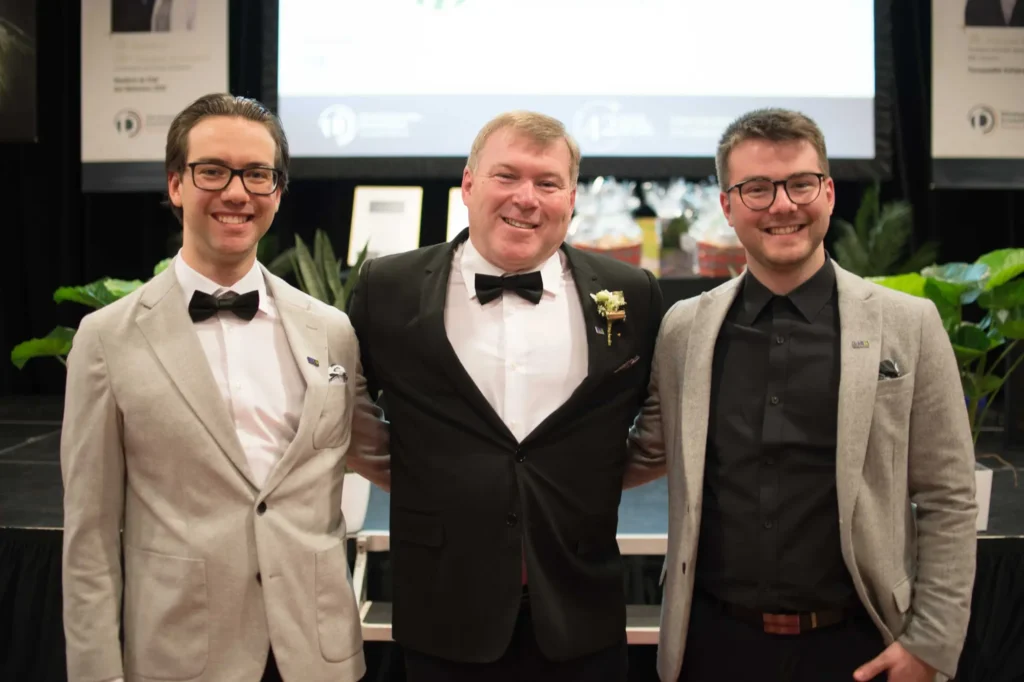 Trois hommes en tenue de soirée souriants