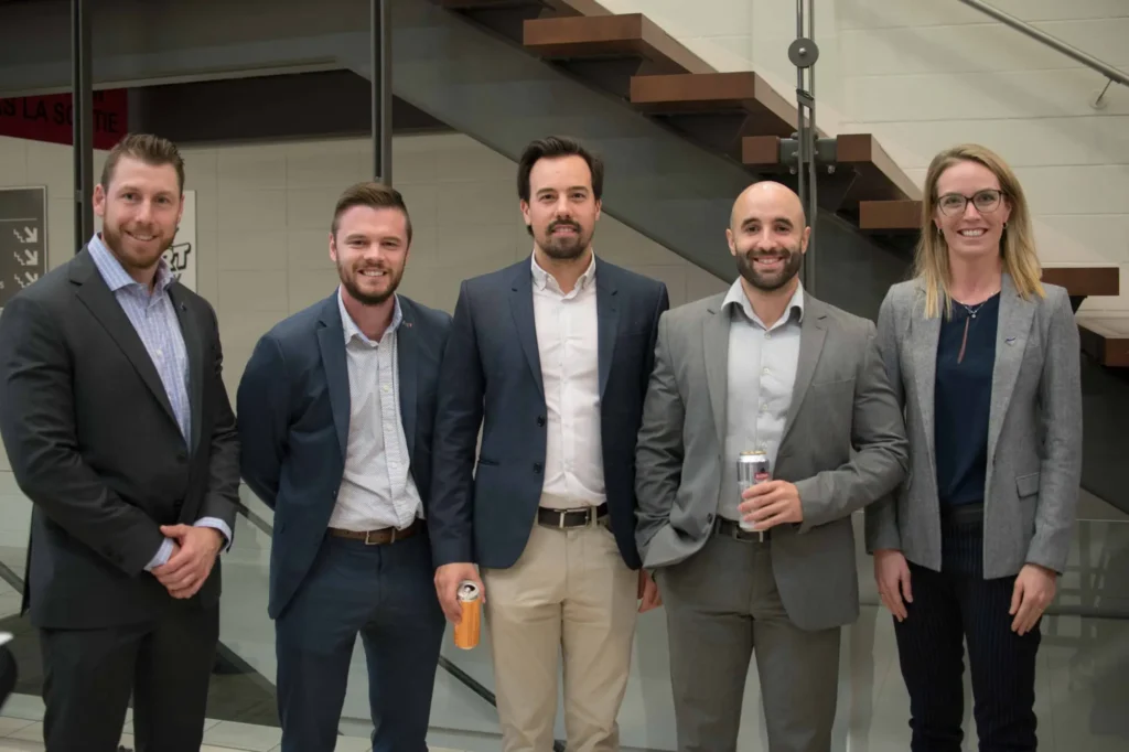Équipe professionnelle posant devant un escalier moderne