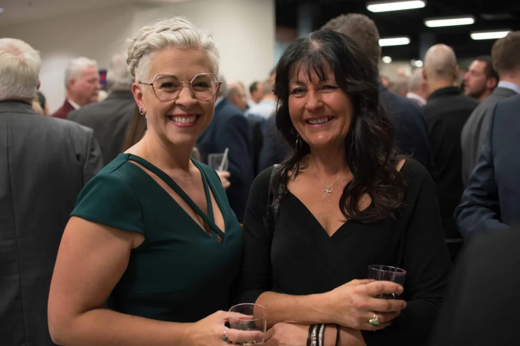 Deux femmes souriantes lors d’un événement formel