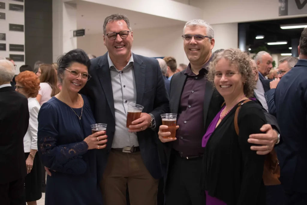 Quatre adultes souriants lors d’un cocktail