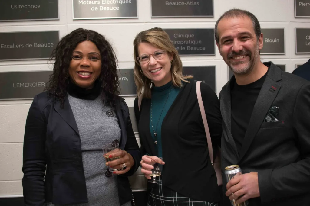 Trois personnes souriantes lors d’un événement professionnel