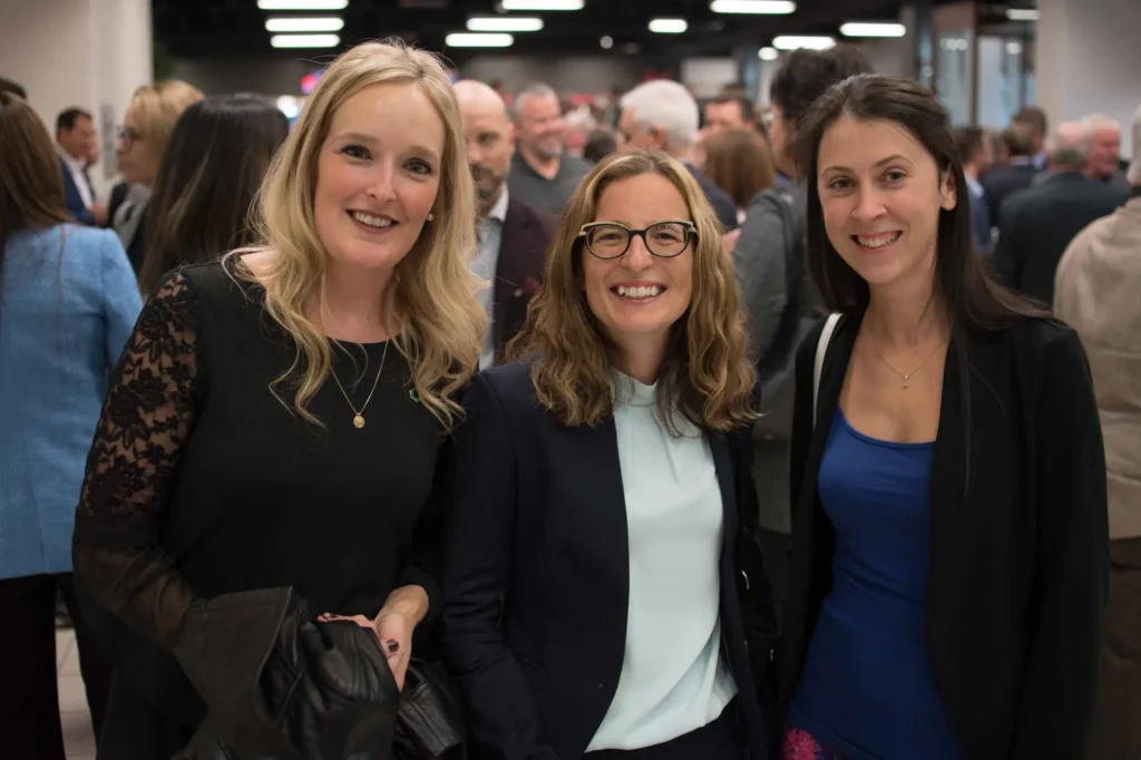 Trois femmes souriantes lors d’un événement professionnel