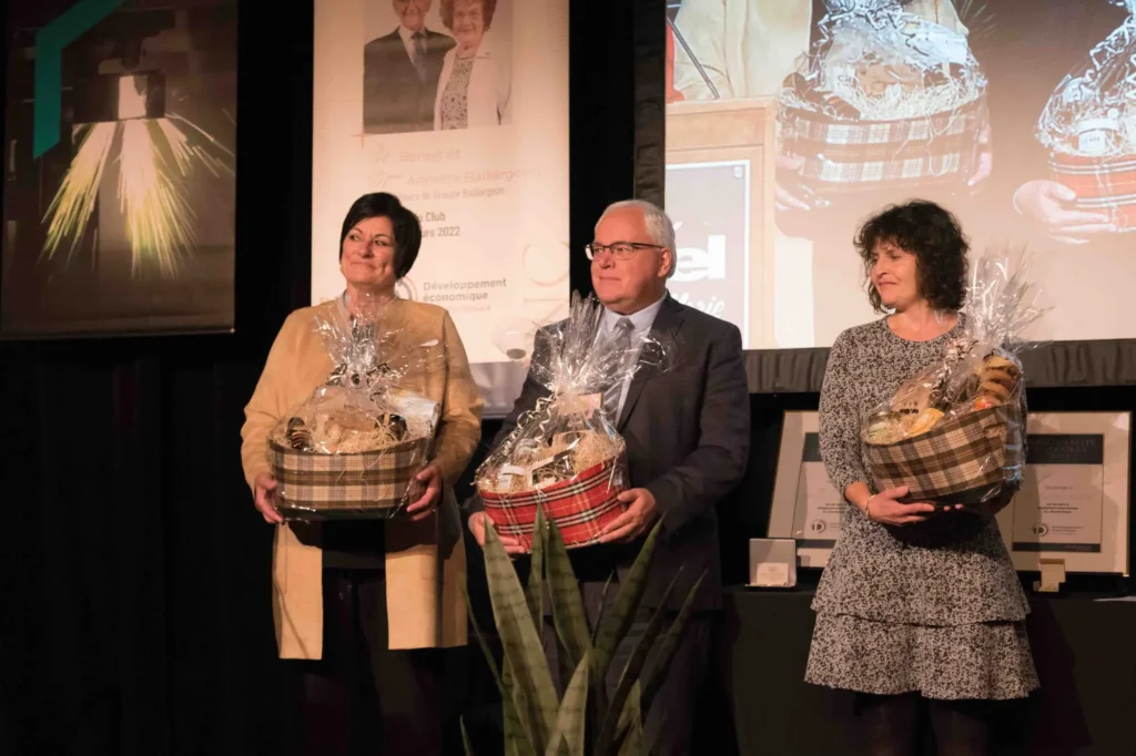 Trois personnes sur scène avec paniers cadeaux