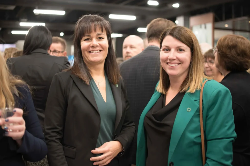 Deux femmes souriantes lors d’un événement professionnel
