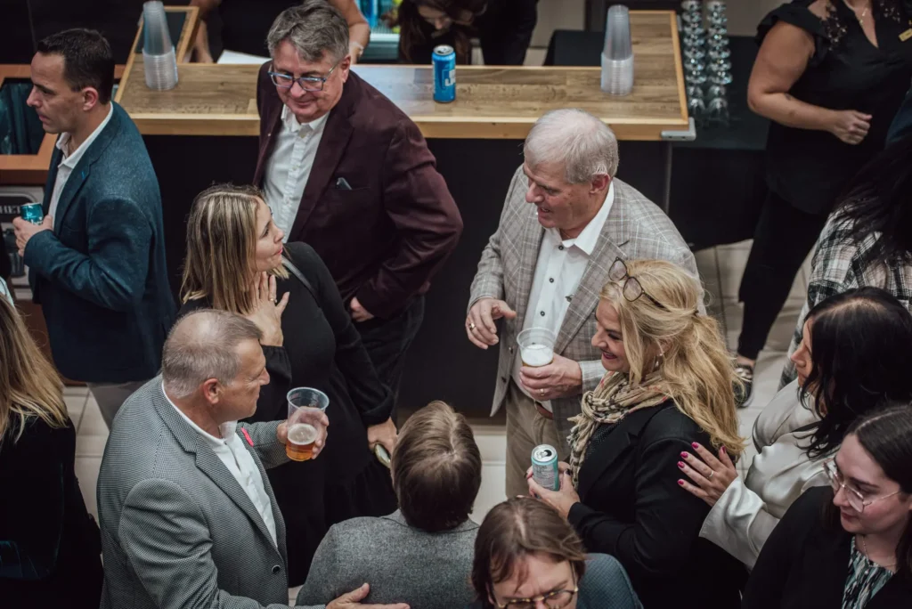 Groupe d’adultes discutant lors d’un cocktail intérieur