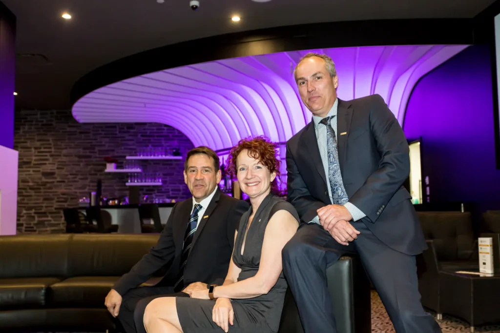 Trois professionnels posant dans un lounge moderne