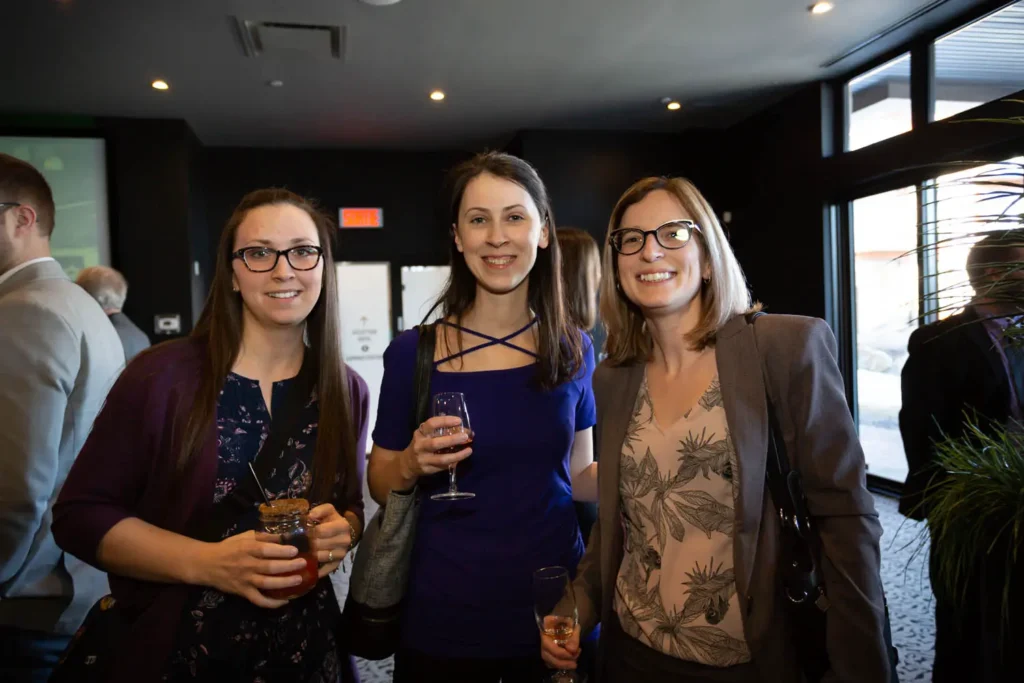 Trois femmes souriantes lors d’un événement professionnel