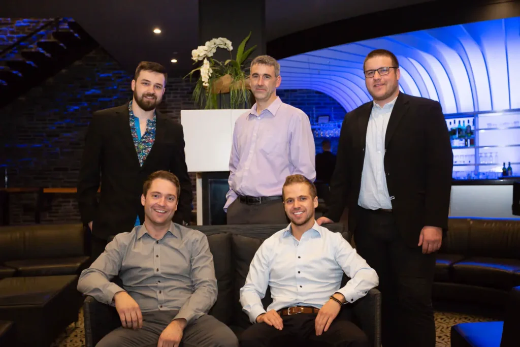 Cinq hommes en tenue professionnelle dans un lounge