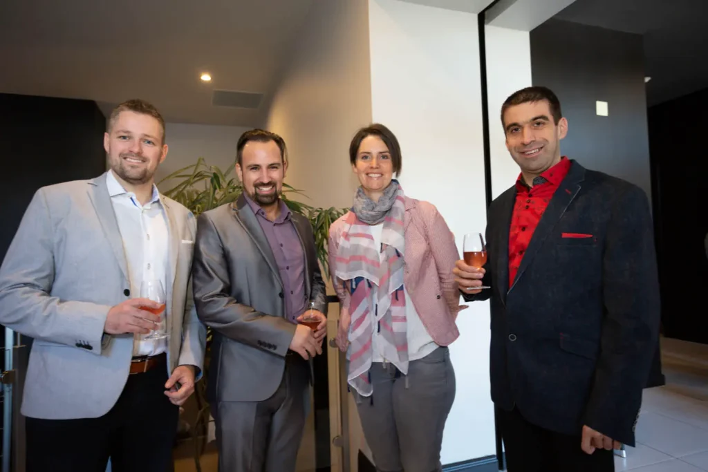 Quatre professionnels souriants lors d’un événement d’entreprise