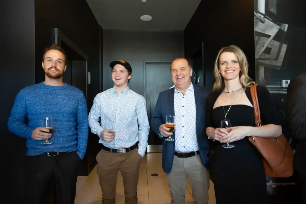 Quatre adultes souriants avec verres lors d’un événement