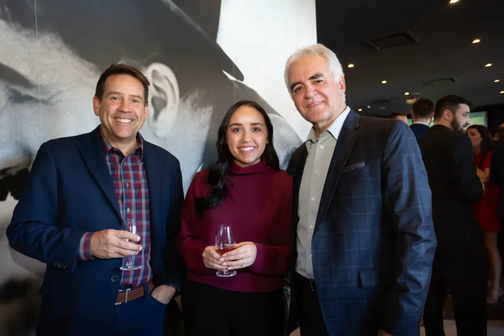 Trois personnes souriantes lors d’un événement professionnel