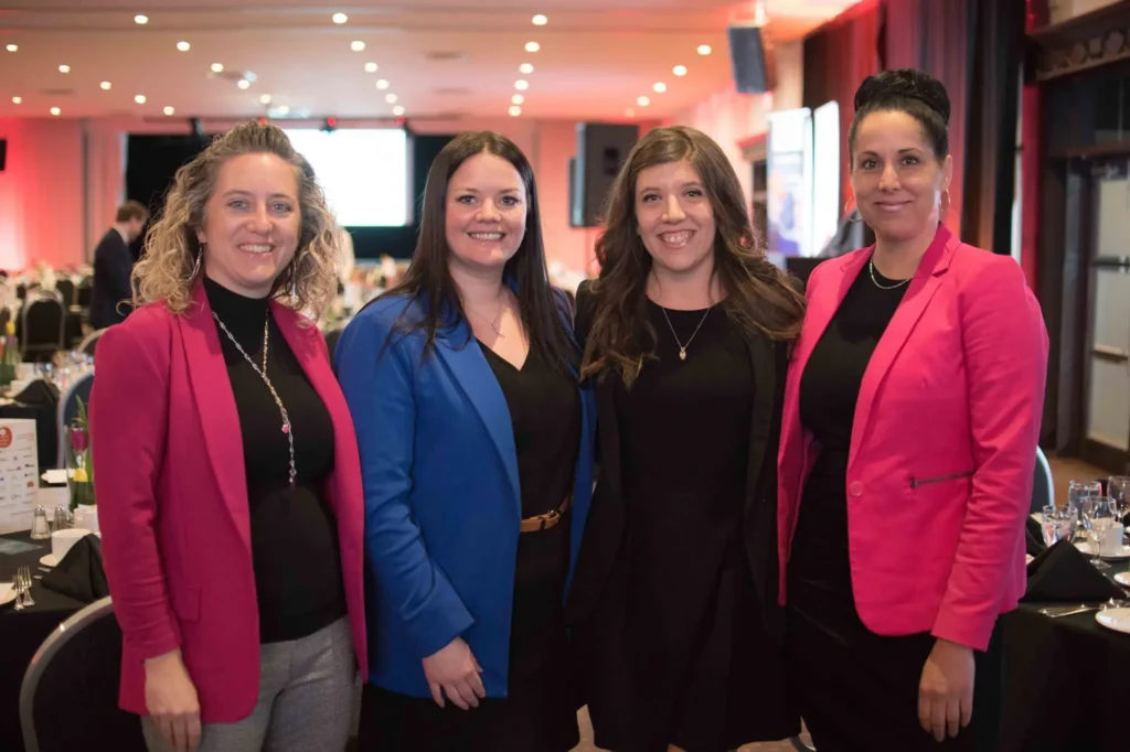 Quatre femmes souriantes lors d’un événement professionnel