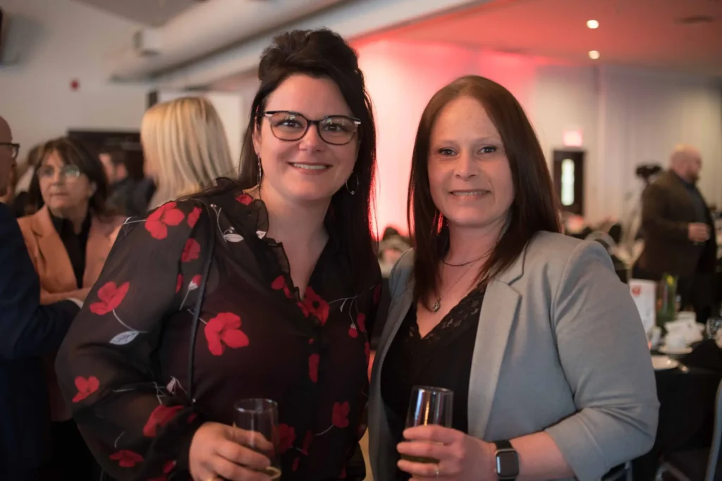 Deux femmes souriantes lors d’une réception intérieure