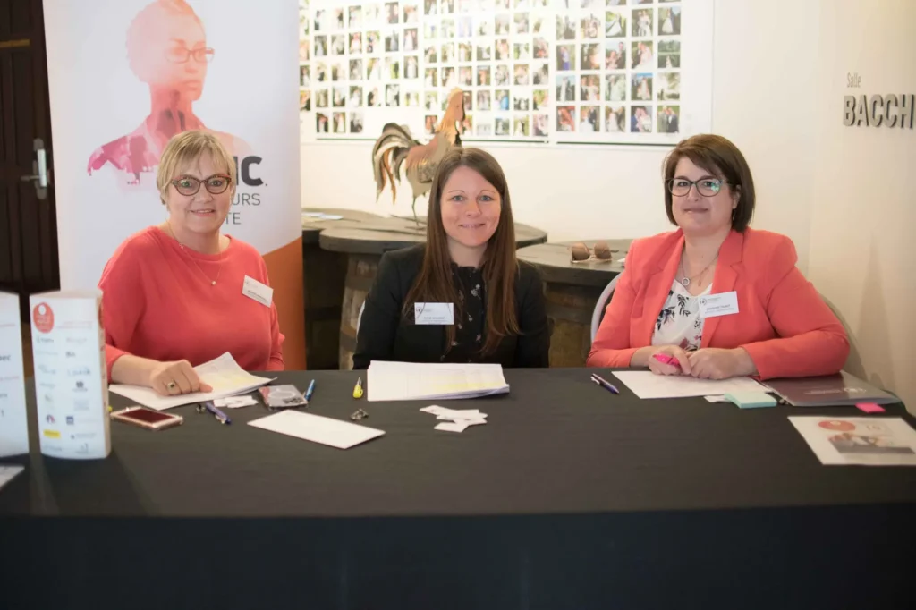 Trois organisatrices à table d’accueil d’événement
