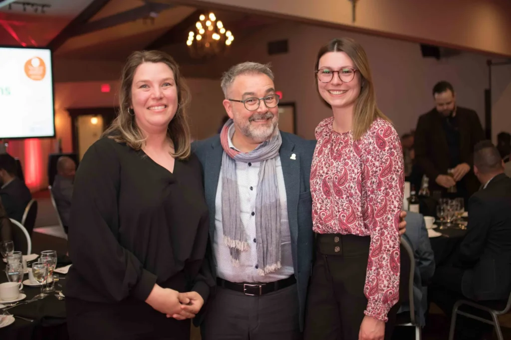 Trois personnes souriantes lors d’un gala