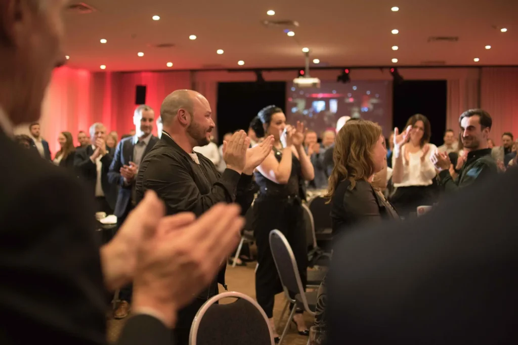 Public debout applaudissant lors d’un événement professionnel