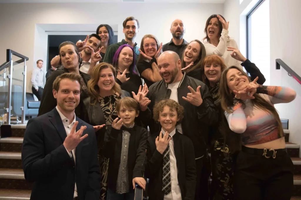 Groupe d’adultes et enfants posant joyeusement en intérieur