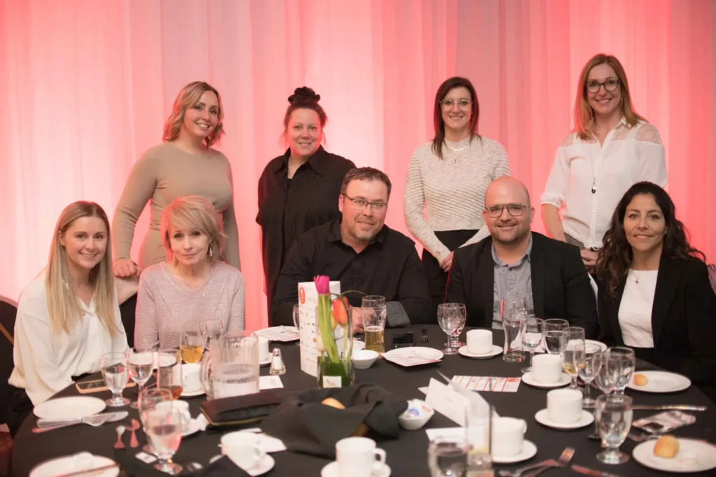 Groupe d'adultes posant lors d'un dîner événementiel