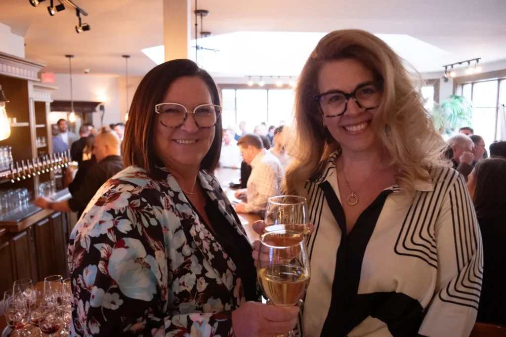 Deux femmes trinquant avec verres de vin blanc