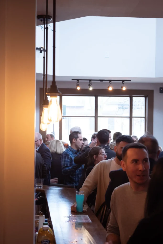 Bar animé avec foule discutant en intérieur