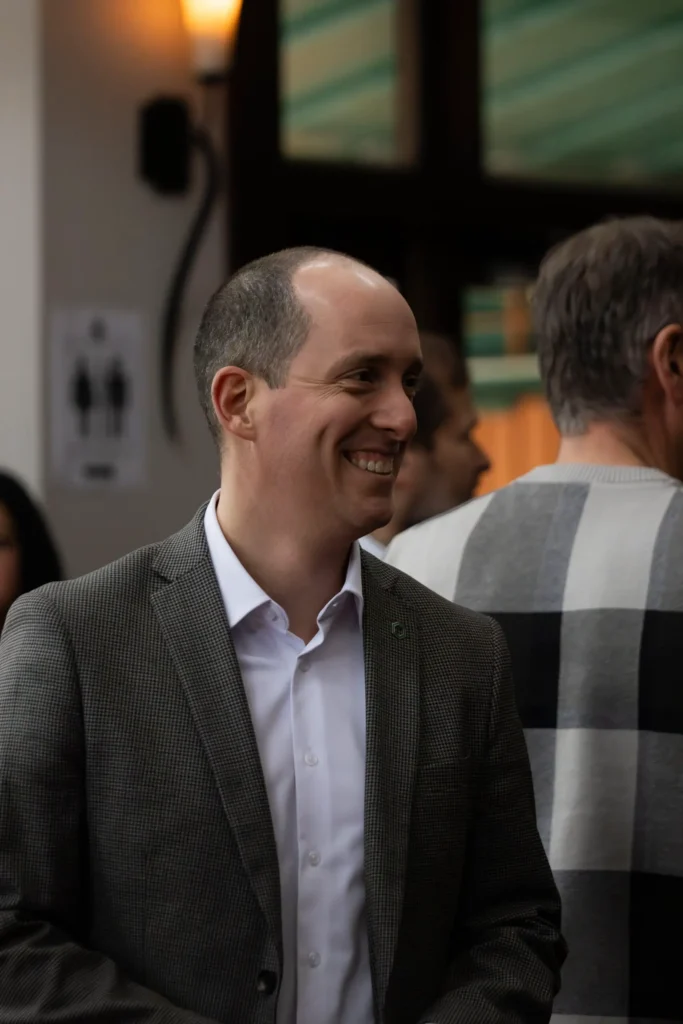 Homme souriant en veste lors d’un événement