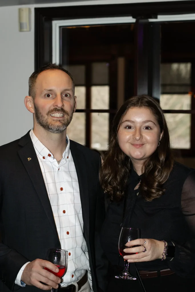 Couple élégant tenant des verres de vin rouge