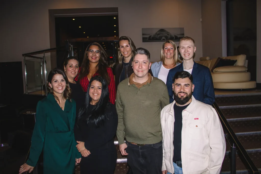 Groupe de huit adultes souriants en intérieur