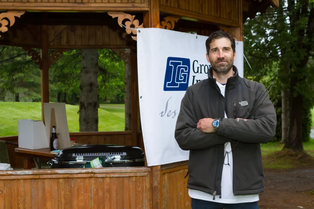 Homme avec clubs de golf devant stand en bois