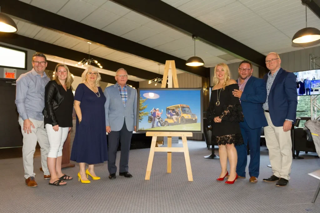 Groupe posant autour d’un tableau de golf