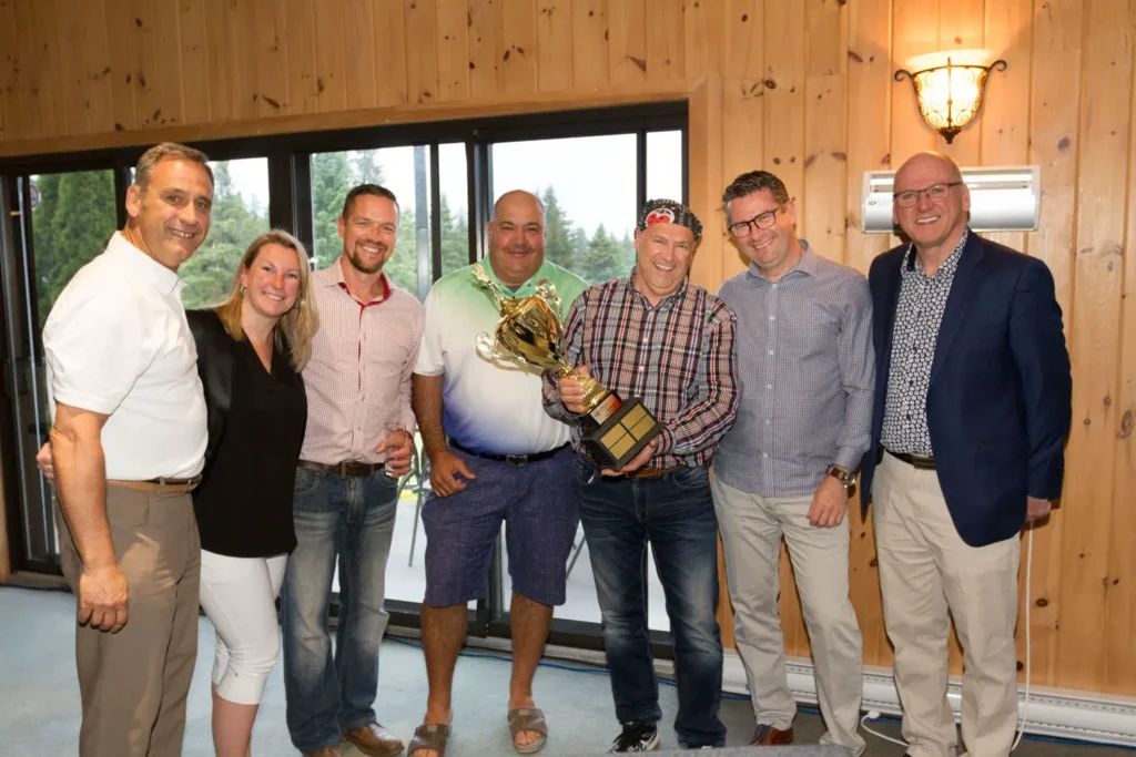 Groupe d’adultes posant avec un trophée